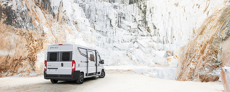 grauer Camper Van mit Blick auf einen großen Berg