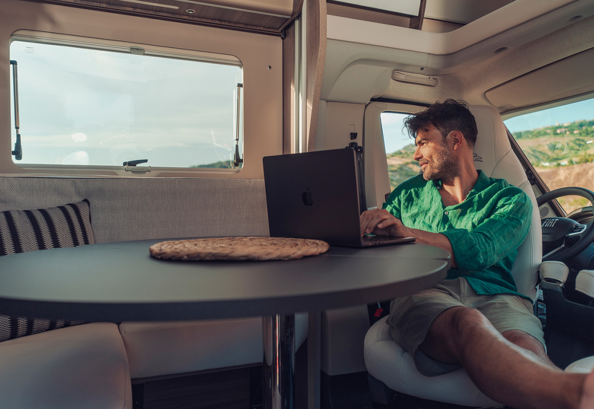 Mann mit Laptop am Tisch
