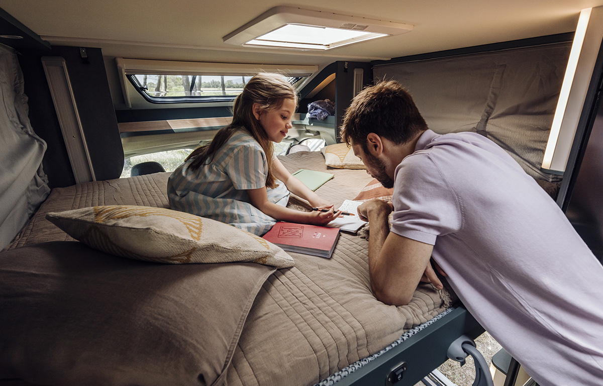 Vater und Tochter malen ein Bild im Reisemobil