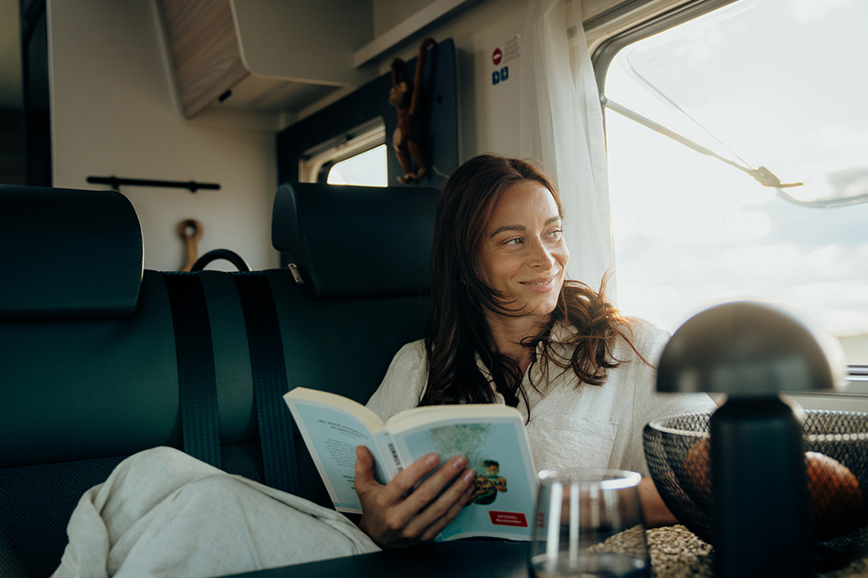 Frau liest Buch im Reisemobil