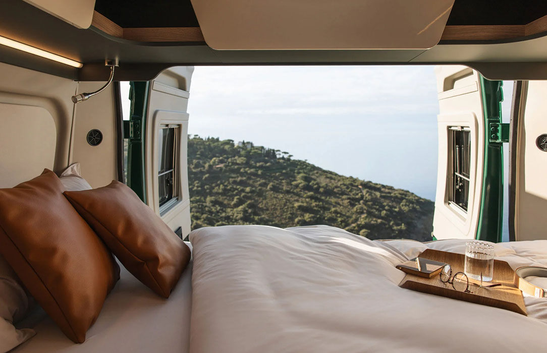 Großes Bett, geöffnete Hecktür mit Blick auf Berge und Meer