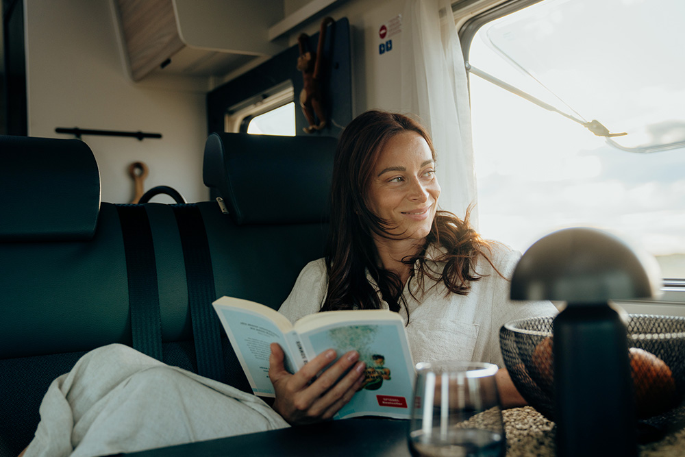 Frau liest Buch im Reisemobil