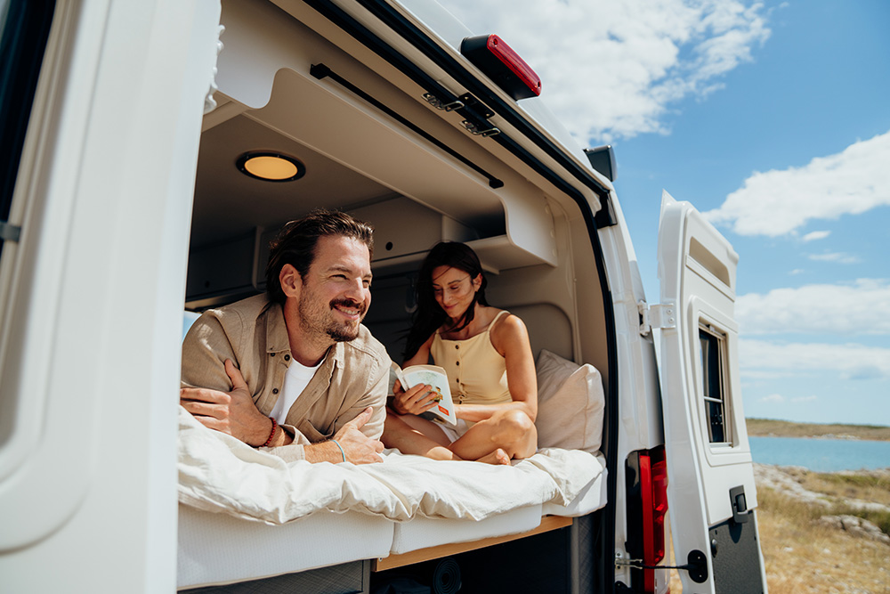 Paar gemütlich im Bett eines Campervans